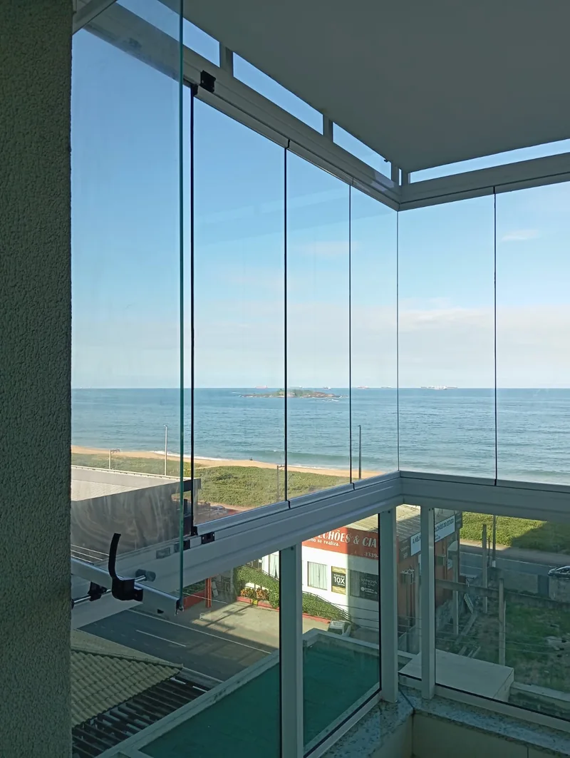 Cortina de vidro instalada em varanda com vista para o mar