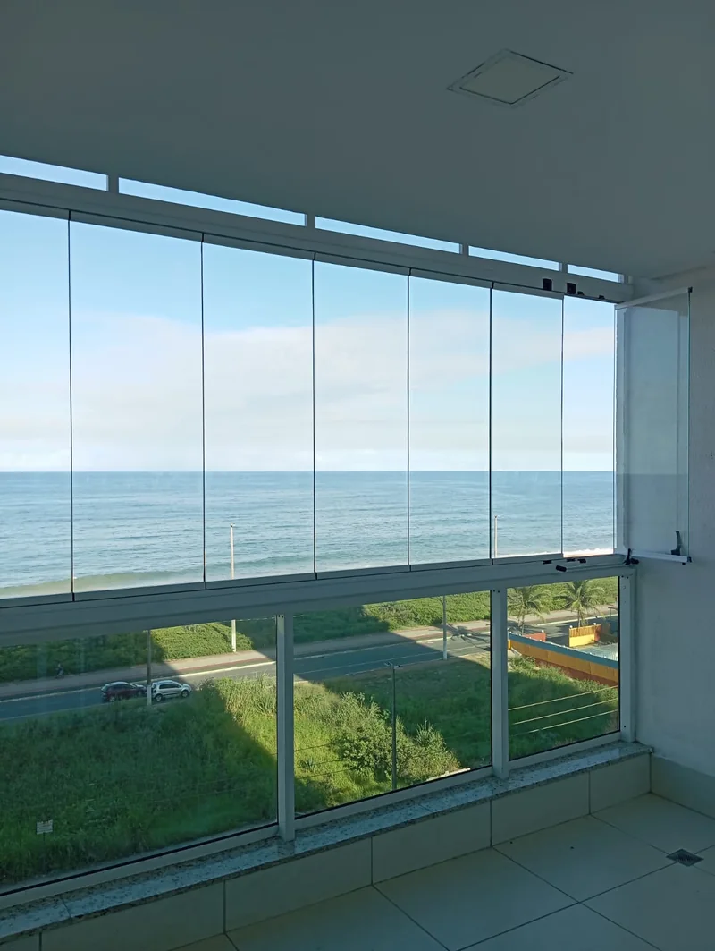 Vista para o mar através dos painéis do fechamento de varanda
